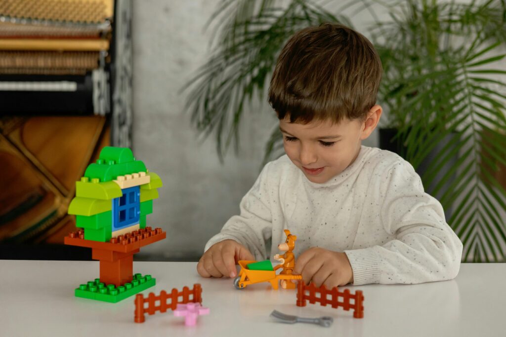 Young boy engaging with toy building blocks on a table. Indoor playtime captured creatively.